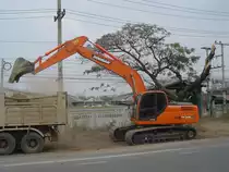 Dieser DOOSAN DX 225 LCA Bagger ist ein Sdkoreanisches Fabrikat und ist hier am 14.02.2044 bei Straenbauarbeiten im Raum von Buri Ram / Thailand eingesetzt.