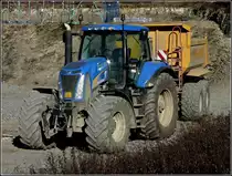 New Holland Traktor mit Kippanh�nger bei einer Baustelle, wartet darauf beladen zu werden. 07.03.2011
