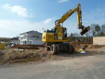 Komatsu PW 140 von der Firma WENDE arbeitet auf einer Baustelle in 36100 Petersberg - Marbach, Mrz 2011
