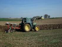 John Deere 6210, mit 3-Schar-Wendepflug bei der Arbeit und angebautem Frontlader, Mrz 2011