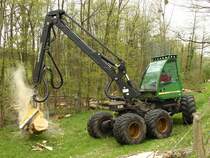 Ein John Deere  1270 D – Harvester bei der Arbeit. An dem Kran ist ein Greifer mit dem die Stmme festgehalten werden und eine Kettensge um das Holz auf Lnge zu schneiden.
