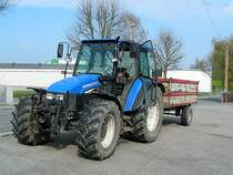 NEW-HOLLAND_TL80 wartet mit Einachsh�nger auf einem Supermarktplatz;110416