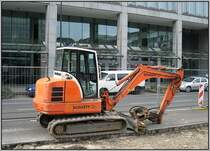 Ein kleiner Bagger des Herstellers Schaeff im Einsatz auf der Elisabethstra�e in D�sseldorf auf H�he des Kirchplatzes. Hier wird eine der unterirdischen Haltestellen f�r die neue U-Bahn-Linie  Wehrhahnlinie  gebaut. Ganz so weit ist es am Aufnahmetag 15.03.2008 aber noch nicht; zun�chst stehen vorbereitende Arbeiten wie Verlegen von Versorgungsleitungen und Versetzen von Stra�enbahngleisen auf dem Programm.