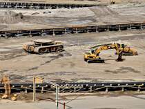 Ein grenvergleich, rechts ein 323D Caterpillar Bagger und eine Caterpillar Raupe, links ein Raupentransporter mit gigantischen Ausmaen. Die Transportflche auf der Raupe kann hydraulisch angehoben werden und ist so gro das z.b.der Bagger oder die Planierraupe spielend darauf Platz finden. Gesehen am 09.08.2011 im Rheinischen Braunkohlenrevier bei Inden. Dort gibt es einen Aussichtspunkt von dem man in das riesige Loch sehen kann in dem die Braunkohle abgebaut wird.