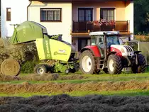 STEYR 6175CVT verrichtet mit KRONE-Comprima-V150XC die Heuernte;110814