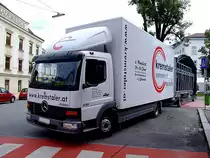 ATEGO-818 der Kremstaler-Veranstaltungstechnik schiebt den mitgefhrten Bhnenwagen Zentimetergenau zum Aufstellungsort beim Neptunbrunnen in Ried;110813