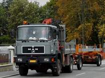 MAN mit Kranaufbau und Kipper zieht einen mit Stahltrgern beladenen Hnger durch die Straen von Wiltz.  10.10.2011