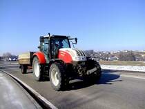 STEYR 6125PROFI ist mit einem Einachshnger und mit hurtigem Tempo auf einer Landesstrae unterwegs  ;120222