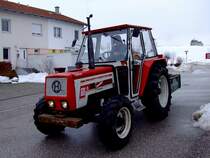 LINDNER 1600A-turbo tuckert mit einer Heckschaufel durch die winterliche Landschaft ;120218