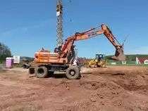 Bagger der Firma  GNTHER-BAU  steht auf einer Baustelle in 36100 Petersberg-Marbach, April 2012