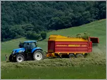 Der New Holland Traktor zieht den Selbstladewagen �ber den Silohaufen wo er diesen entleert. 24.07.2012