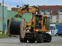 Atlas Zweiwegebagger mit einer Kabeltrommel am ausgestreckten Arm am 28.08.2012 in Aachen West.