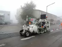 Stra�enmarkierungsmaschine bringt bei dichtem Nebel Farbe auf den Asphalt; 121020