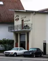 Porsche 911 (G-Modell) und Mercedes-Benz Mercedes SL Roadster (R107) parkieren vor dem Garage48 in Hockenheim. (Foto: 13.10.2012)