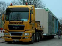 MAN TGX 26.480 mit einem berbreiten 16m langen Modulbauteil auf dem Auflieger am 10.01.2012 in Aachen.