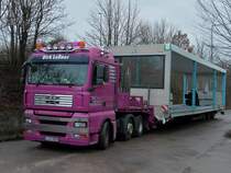 MAN TGA 26.480 mit einem berbreiten 16m langen Modulbauteil auf dem Auflieger am 10.01.2012 in Aachen.