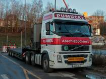 Hurra, der Pumuckl ist da. Ein Volvo 480 mit Teleskopauflieger der Firma Pumuckl aus Bucha bei Jena steht am 11.01.2013 auf einem Parkplatz des neuen Campus in Aachen. Der Fahrer hat ein 16m langes berbreites Baumodul nach hier gefahren, wurde abgeladen und mu nun seine Ruhezeit einhalten bevor er weiterfahren kann.