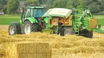 Deutz Agrotron mit Krone Big Pack Ballenpresse.Die Bindegarnrollen m�ssen gewechselt werden.Gesehen am 1.August 2012 n�he Elfrather See.