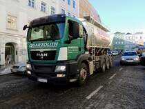 MAN TGS 35.440 von Quarzolith, mu sich mit seinem Silotankaufbau durch den Hauptplatz von Ried qulen, um an der Baustelle die bentigten Baustoffe abliefern zu knnen; 130305