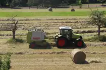 Geballt - Der Sommer ist da - Zeit f�r´s Heu -

Es ist doch sch�n, wenn man einen Photostandpunkt gaaanz in der N�he hat.

Was hei�t N�he. Mein Dachstudio Fenster bietet den �berblick auf das landwirtschaftliche Geschehen hinter unserem Haus.

Nachdem das Heu mehrmals gewendet wurde (zu meiner Kindheit oft noch Handarbeit) mu� es ja irgendwann in die Scheune. Ich kenne es noch lose auf dem Wagen (bis Mitte der 60er noch mit Pferd).
Dann kamen die Ballen, die oftmals mit  primitiven  Maschinen gepresst und gebunden wurde. Wie oft war die Schnur kaputt....

Ballen gibt es zwar Heute noch aber man sieht immer mehr runde Ballen.
24.07.2012

Hier der Blick auf Claas Axos 320 Zugmaschine und Claas Rollant 46 Rundballenpresse.