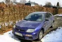 Ein Mazda 323 steht in der Einfahrt in Waimes(B) bei Sonnenschien und Schnee liegt am 26.3.2013.