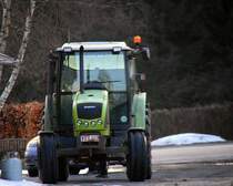 Ein kleiner Claas Trecker parkt auf dem Weg vom Bauernhof in Btgenbach(B) in der Abendstimmung am 26.3.2013.