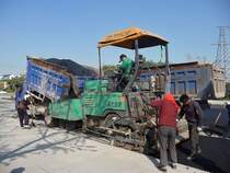 Im Gegensatz zur  Kurzstrecke  bleibt der Kipper vor dem Asphaltfertiger, der den LKW vor sich her schiebt. 
Shouguang, 16.10.11