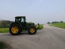 John Deere-6400 wird von einem Feldweg in die Hauptstra�e einbiegen; 130501