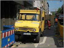 Dsseldorf, U-Bahn-Projekt Wehrhahnlinie, knftiger Haltepunkt Benrather Strae, 06.05.2008: Bei der Verlegung von Kabeln und anderen Versorgungsleitungen war dieser ltere Unimog mit Kastenaufbau anzutreffen. Seltsamerweise trug er an der Seite die Aufschrift  DBP Fernmeldepost  mit dem Posthorn-Logo.