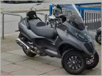 Piaggio MP3 Touring 500ie Motorroller abgestellt am Rande des B�rgersteigs. 22.09.2013.