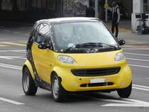 Schwaz- Gelber Smart unterwegs in der Stadt Genf am 11.01.2014