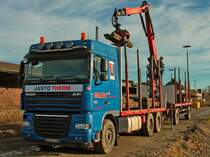 Ein DAF 105.460 Hängerzug läd am 16.12.2013 mit seinem Ladekran (Palfinger E165Z Plus) alte Betonschwellen in Aachen West.