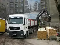 MAN TGX 18.440 wird am 15.01.2014 in Berlin-Charlottenburg von einem Volvo-Kettenbagger mit Bauaushub beladen.