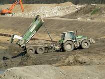 Deutz-Fahr Schlepper mit Tandem-Kippanhänger hat den Unterwasser-Aushub am 14.03.2014 auf der Baustelle Schleuse Zerben am Elbe-Havel-Kanal abgekippt. Anschliessend wird das Material auf SL (Schubleichter) verladen.