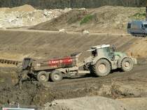 Deutz-Fahr Schlepper mit Tandem-Kippanhänger am 14.03.2014 auf der Baustelle Schleuse Zerben. Schön zu sehen wie nach dem Öffnen der Bordklappe der zum Teil flüssige Unterwasser-Aushub rausschwappt.
