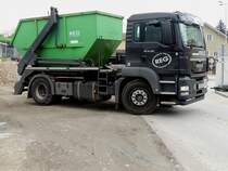 MAN TGS18.400 stellt einen Absetzcontainer bei einer Baustelle zu; 140429