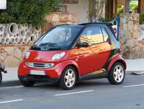 Rot / Schwarzer Smart in den Strassen von Roses (Spanien) am 27.09.2014