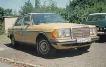 Mercedes-Benz W123 230 mit Vergaser (109 PS) Baujahr 1979 in Saharagelb im Sommer 1994 in Leipzig.
